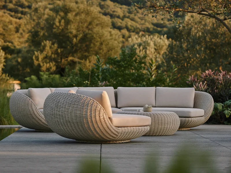 Illustration eines geschwungenen Loungesets mit tiefen Polstern auf einer Gartenterrasse